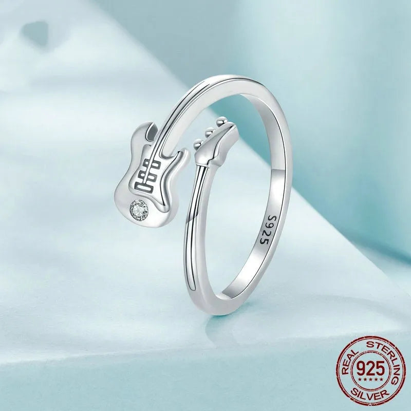 S925 silver oxidised open ring with guitar ornament on neutral background