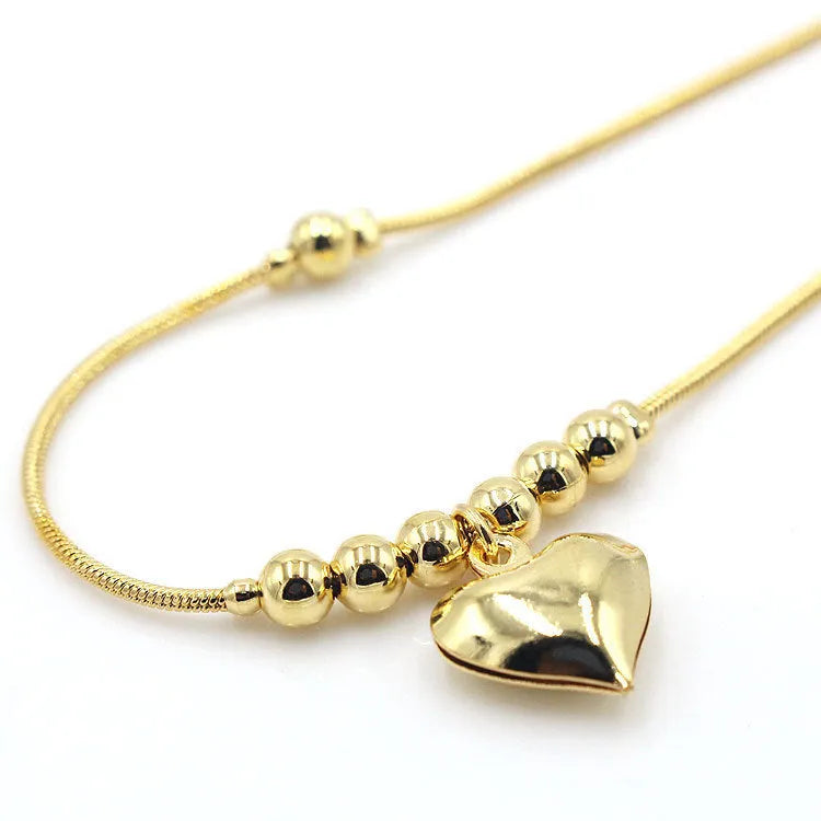 Gold colour gothic heart pendant anklet on a woman's ankle with chunky ball beads and copper chain 27cm