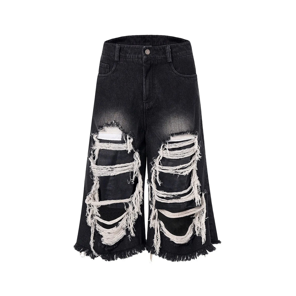 Black wide leg cropped jeans with distressed patch details on the legs, showing a mid-high waist.