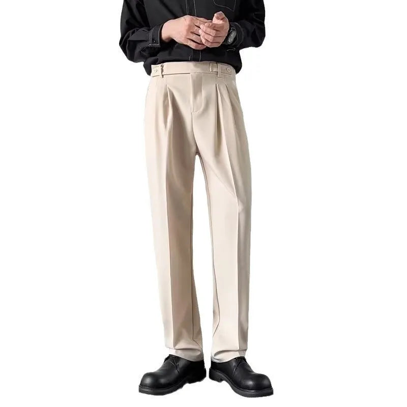 Men's apricot and black straight-leg suit trousers laid flat, showing loose fit and formal design.