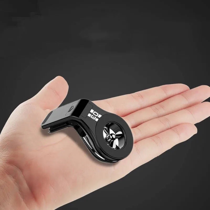 Black magnetic car phone holder clipped to a car air vent, holding a smartphone.