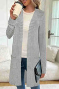 Long sleeve loose fit knitted cardigan jacket in black, shown on a hanger.