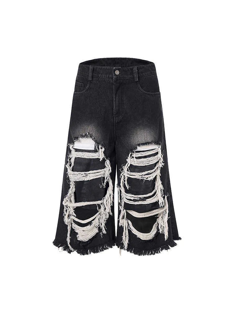 Black wide leg cropped jeans with distressed patch details on the legs, showing a mid-high waist.