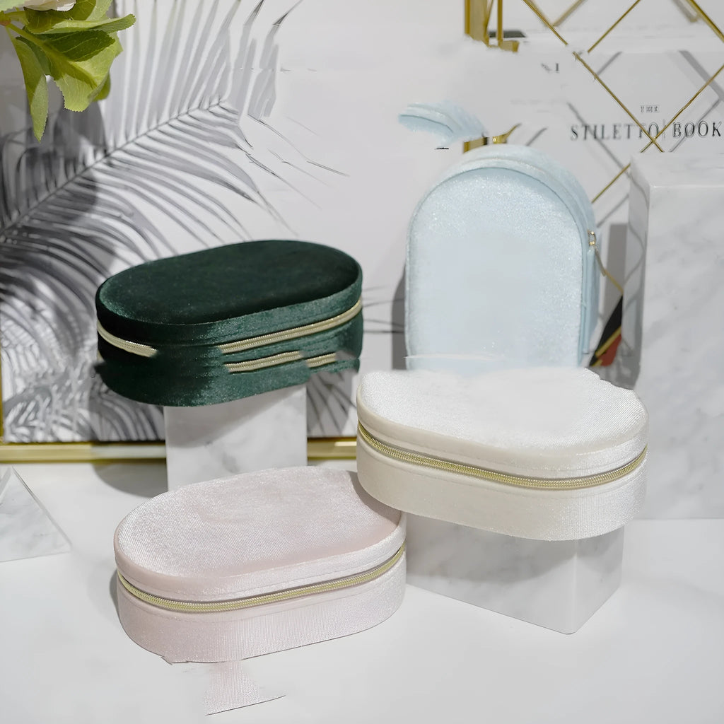 Oval-shaped lake blue velvet jewellery box with flannel lining and a metal inner hook for earrings.