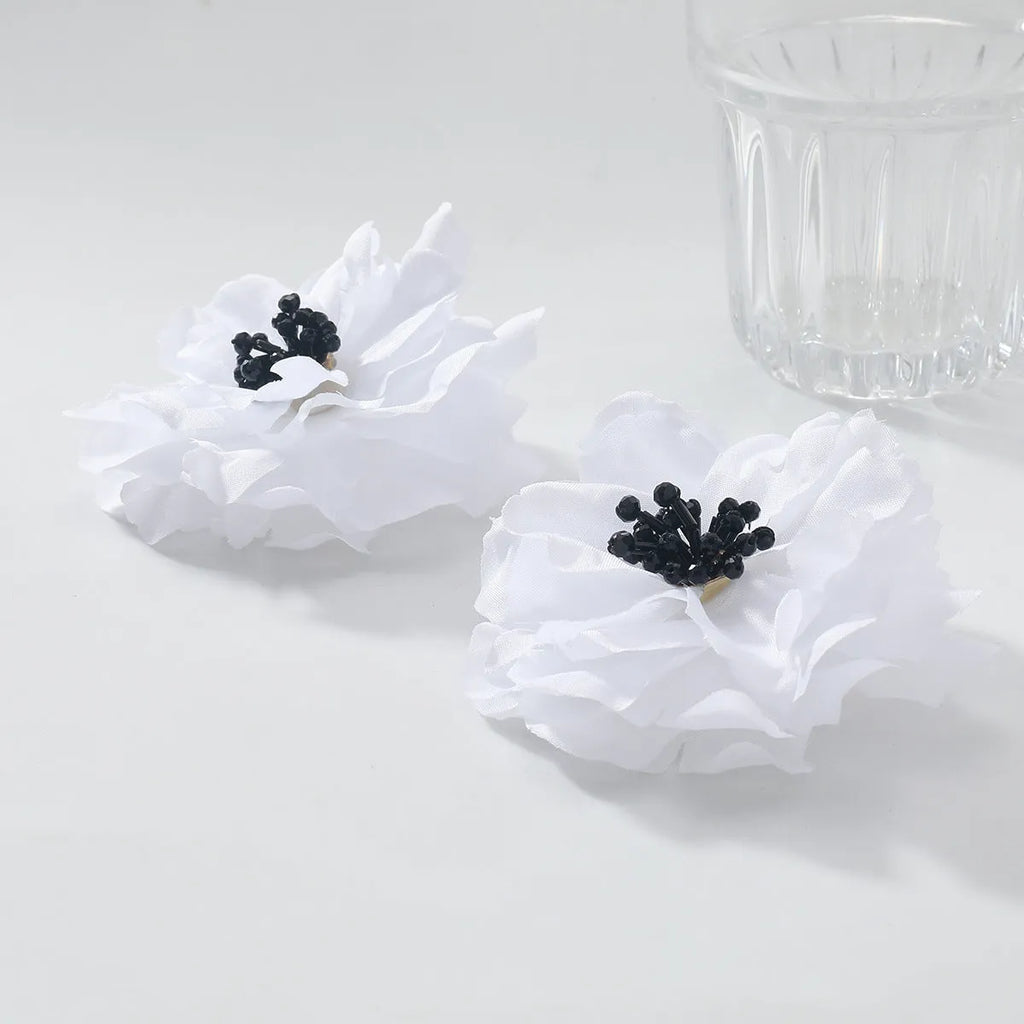 Hand-woven white plastic resin flower earrings for women fashion OL style on display
