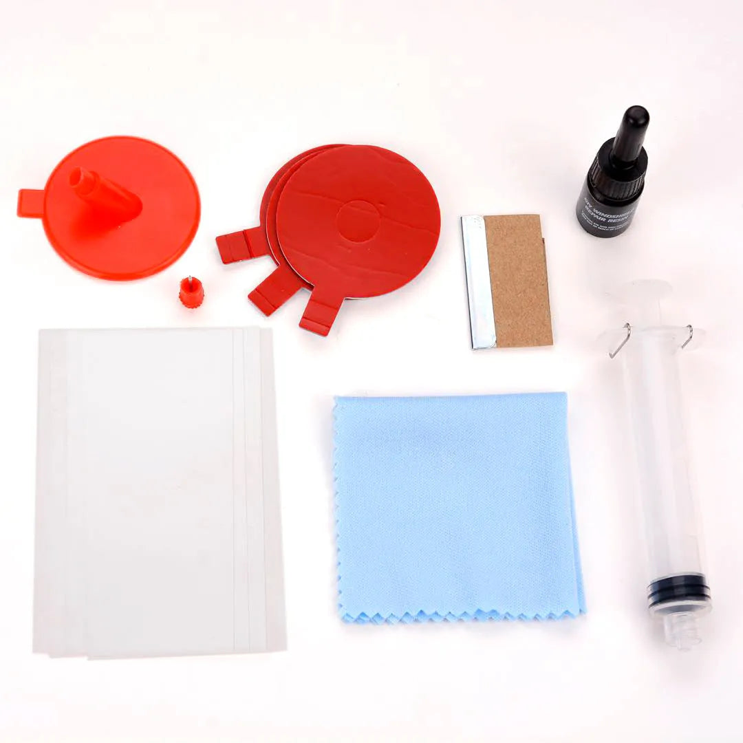Car windscreen repair kit box containing UV lamp, green resin syringe, injection tools, and yellow bracket.