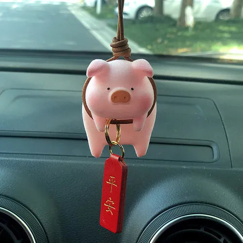 A cute cartoon pig resin figurine car decoration accessory on a dashboard.