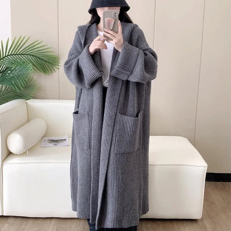Loose-fitting beige hooded cardigan coat for women with raglan sleeves on a hanger.