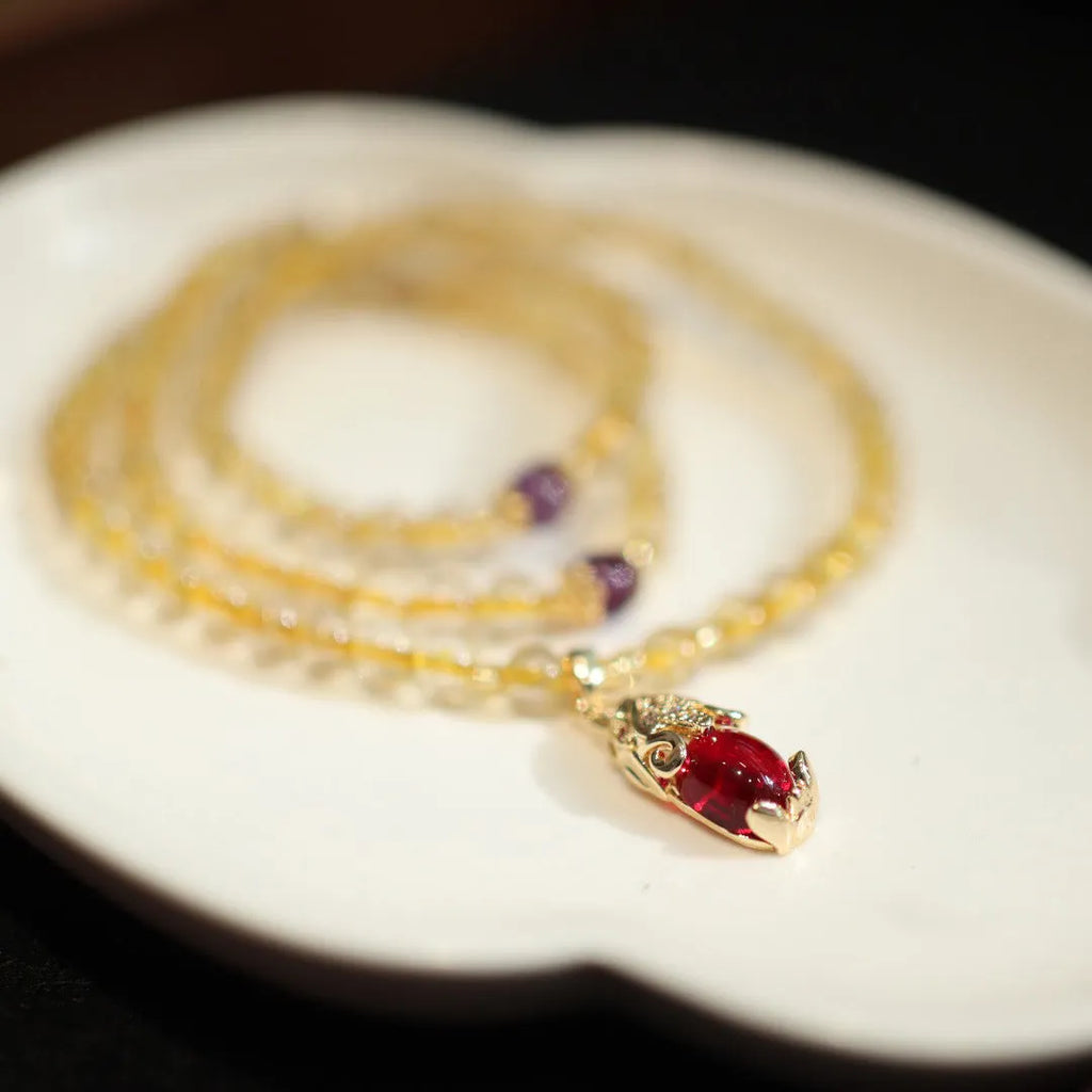 Natural Brazilian rutilated quartz bracelet with gold accents and Chinese-style charms on adjustable cord