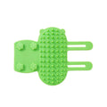 Silicone cat grooming comb with rounded teeth and adjustable strap mounted on a table leg.