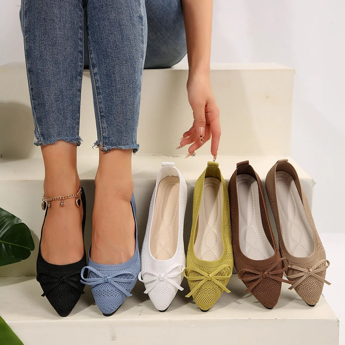 Women's knitted flat loafers with a bow and pointed toe in blue, shown from the side.