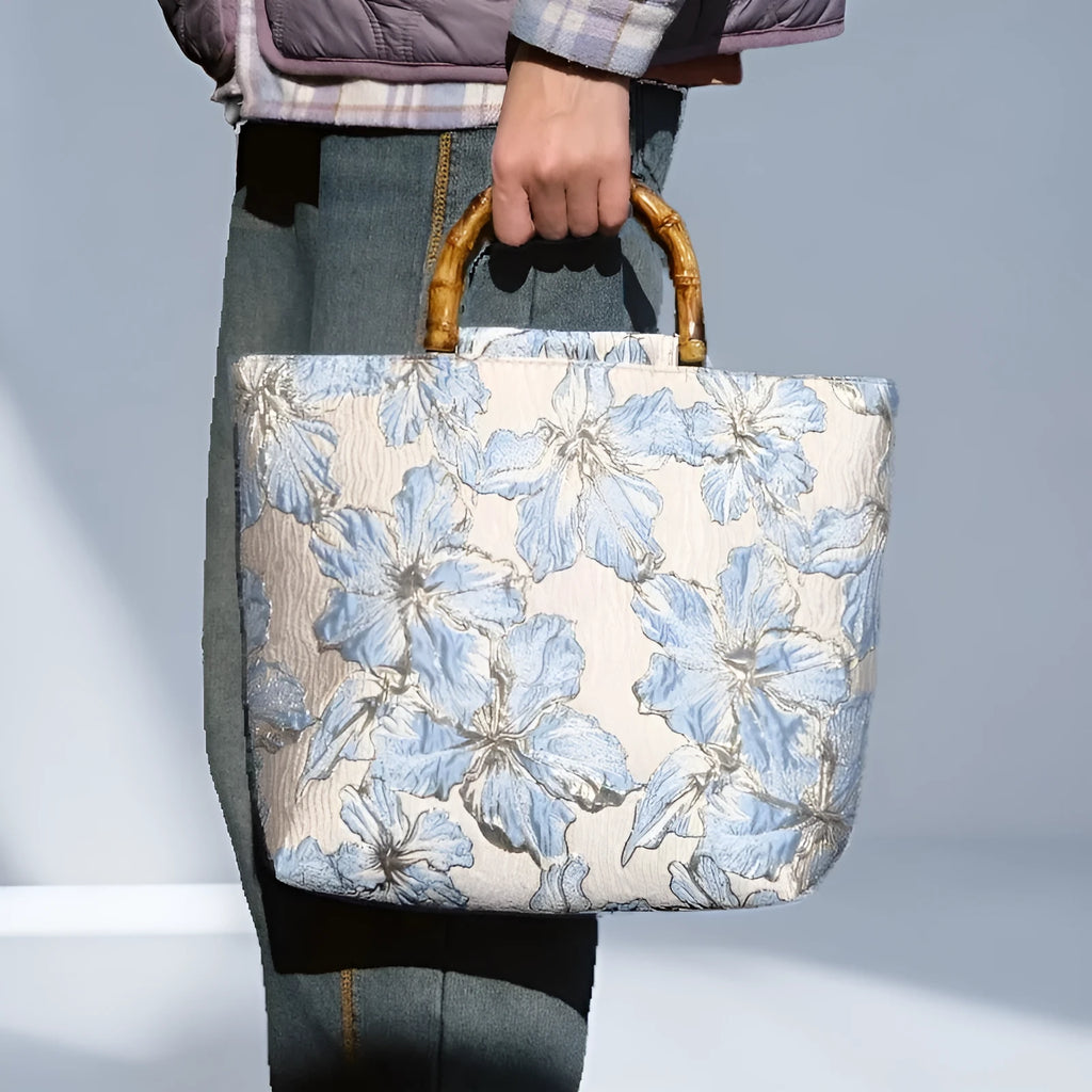 Light blue canvas shoulder bag with bronzing flower pattern, showing square shape and double shoulder straps