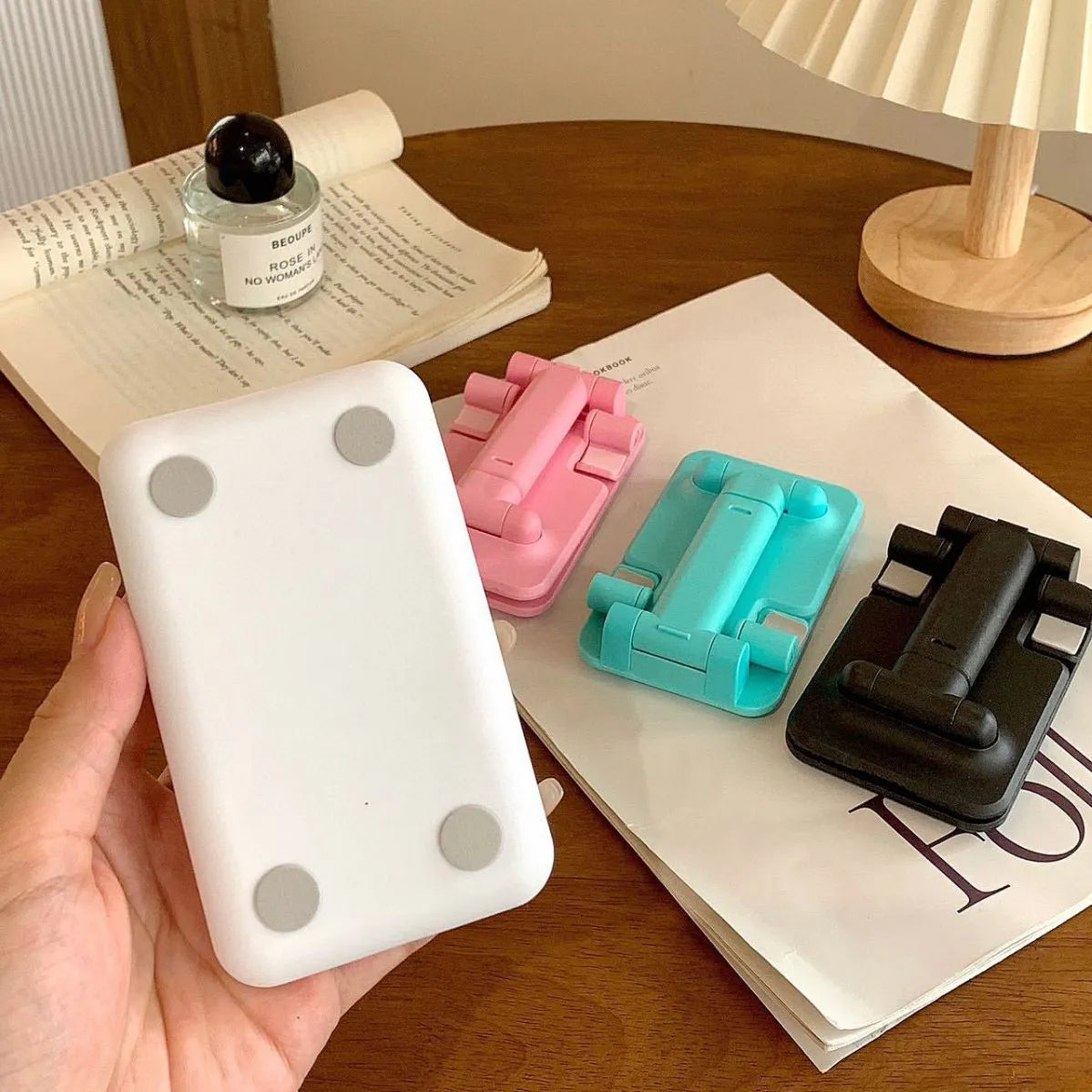 Folding plastic mobile phone stand in white, showing universal groove for hands-free viewing
