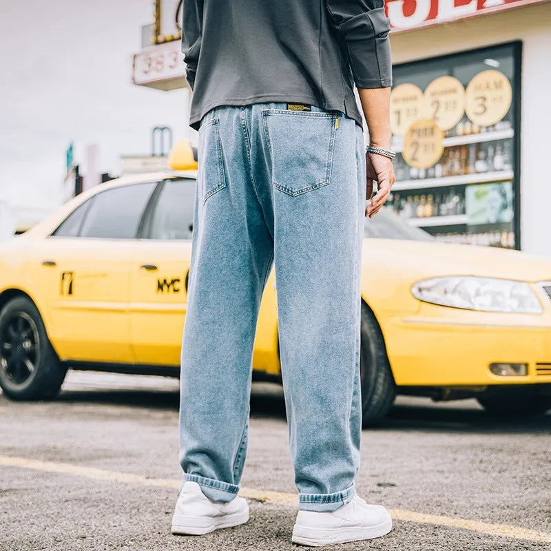 A pair of men's loose-fitting straight-leg casual jeans in dark blue cotton fabric.