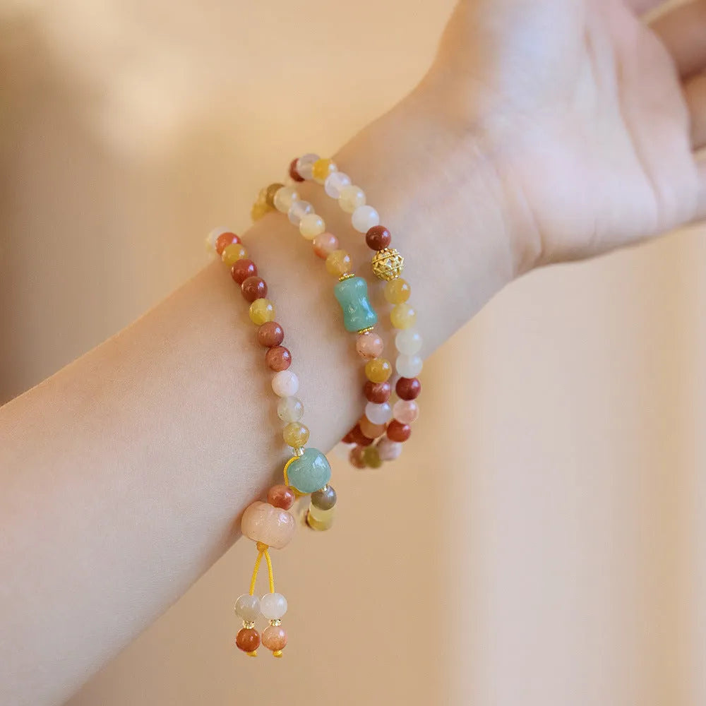 Women's Jinsi Jade bracelet with pumpkin tassel on a 14-16cm wrist.