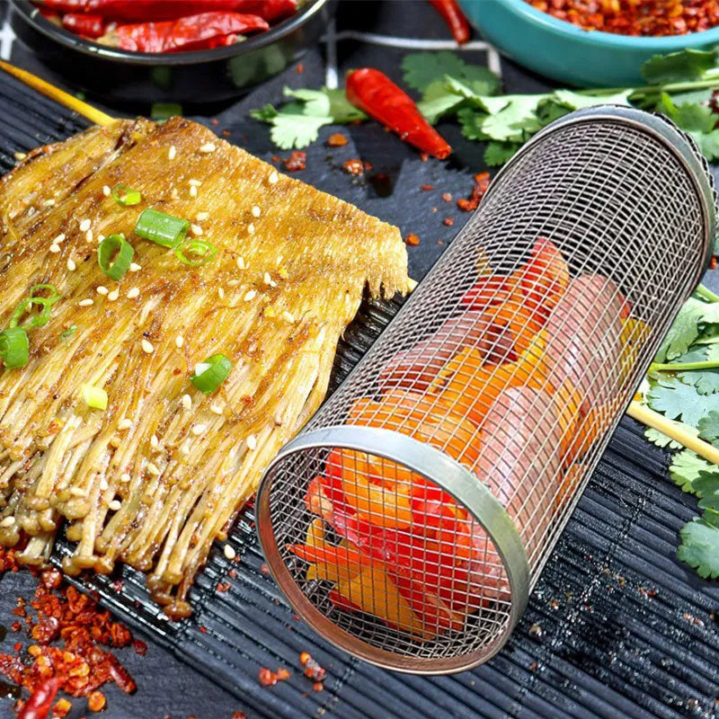 Stainless steel cylindrical rolling barbecue grilling basket with wire mesh on a grill.