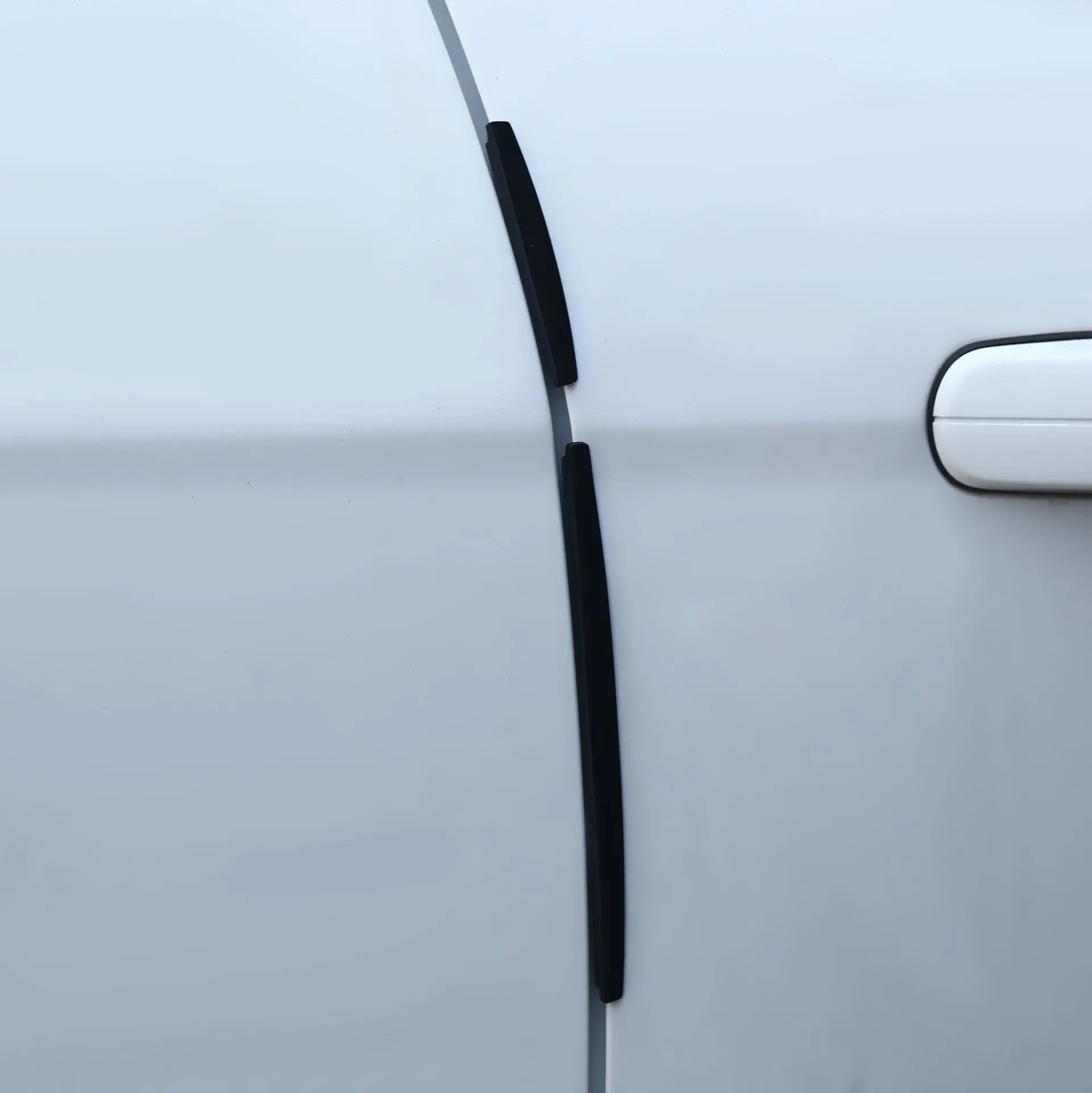 White plastic car door edge protection strip with adhesive backing, shown in packaging.