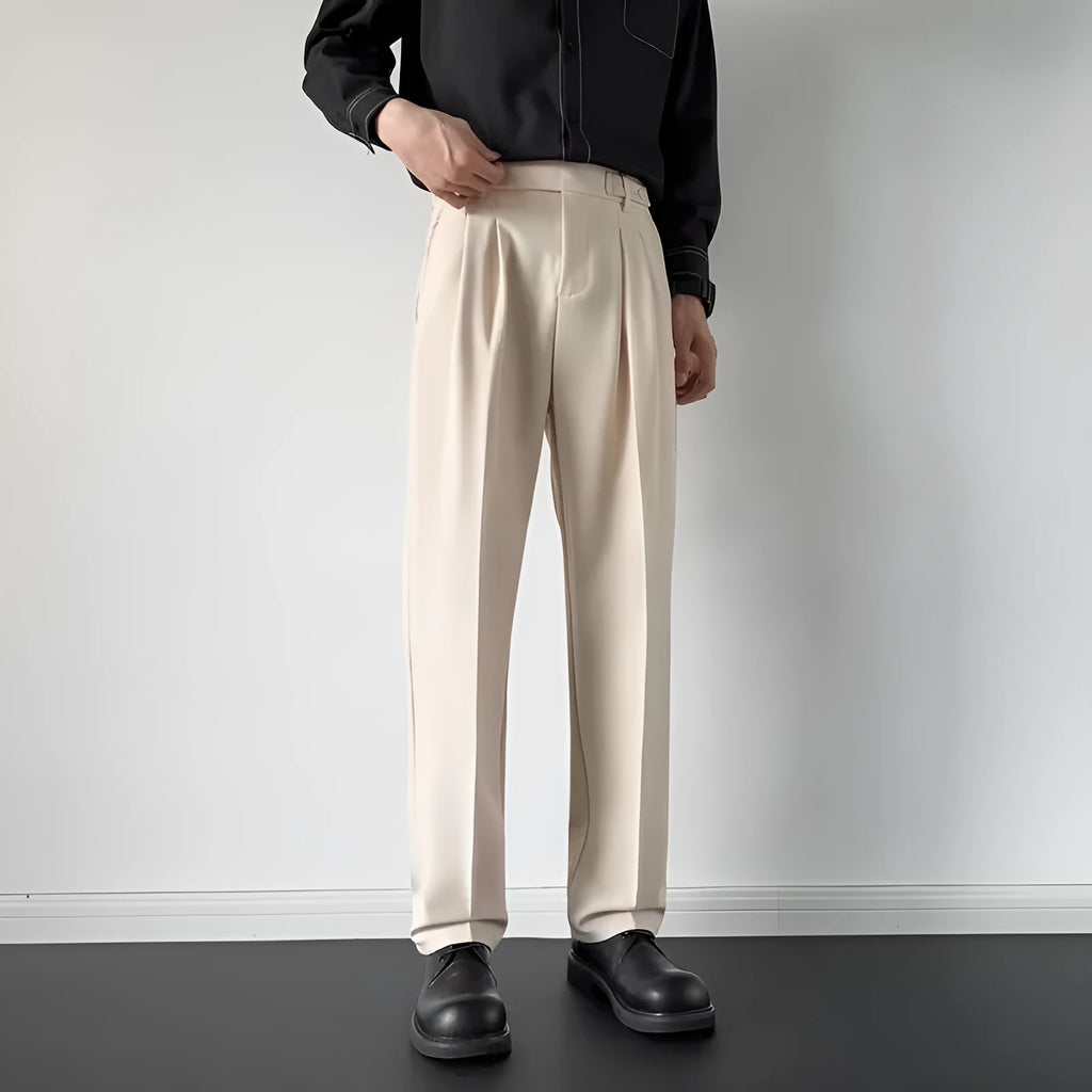Men's apricot and black straight-leg suit trousers laid flat, showing loose fit and formal design.