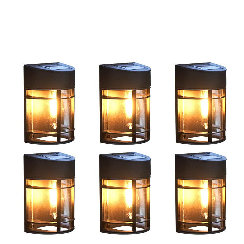 Small solar-powered outdoor wall light with warm white glow, mounted on an exterior wall.