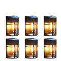 Small solar-powered outdoor wall light with warm white glow, mounted on an exterior wall.