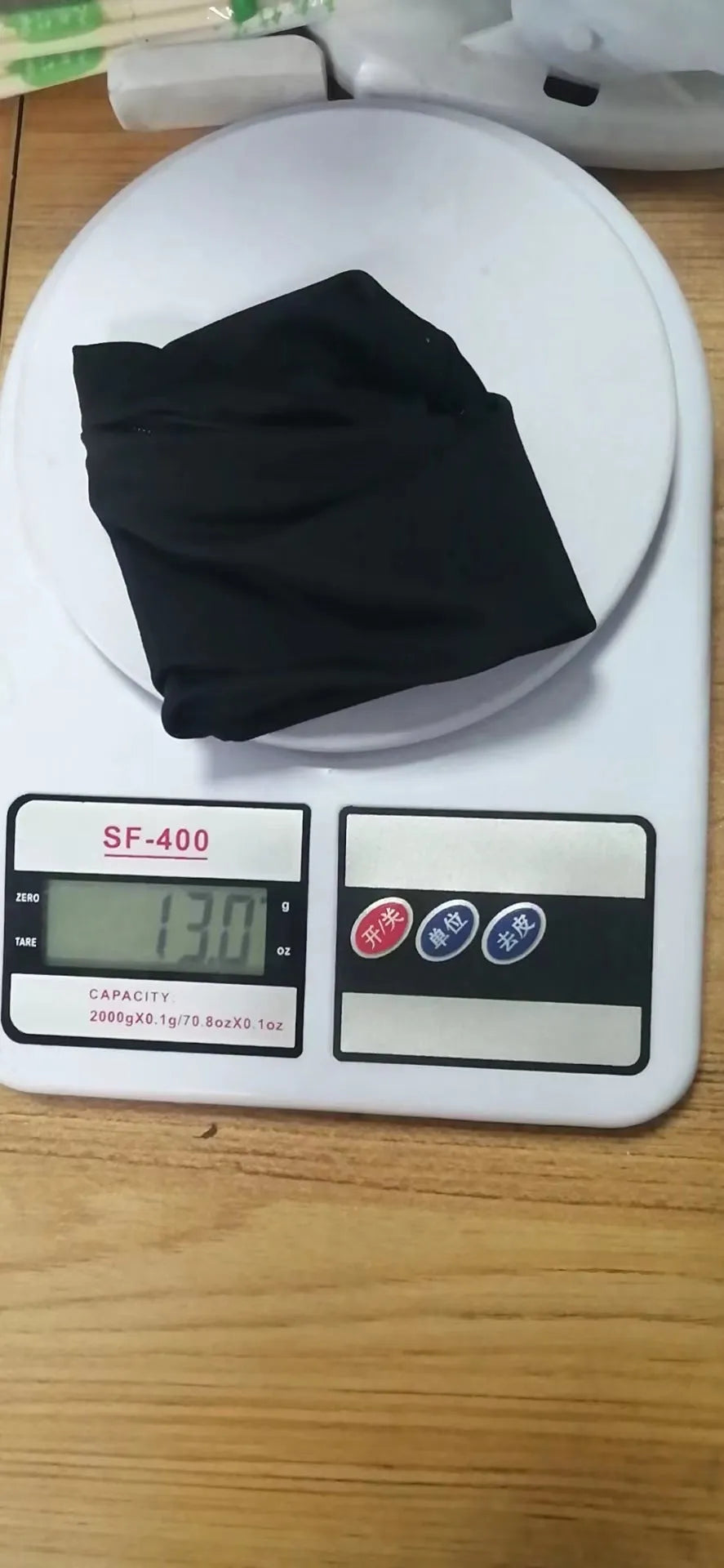 Black adjustable wrist bag with armband, showing zipped main compartment and external card slot on a person's forearm.