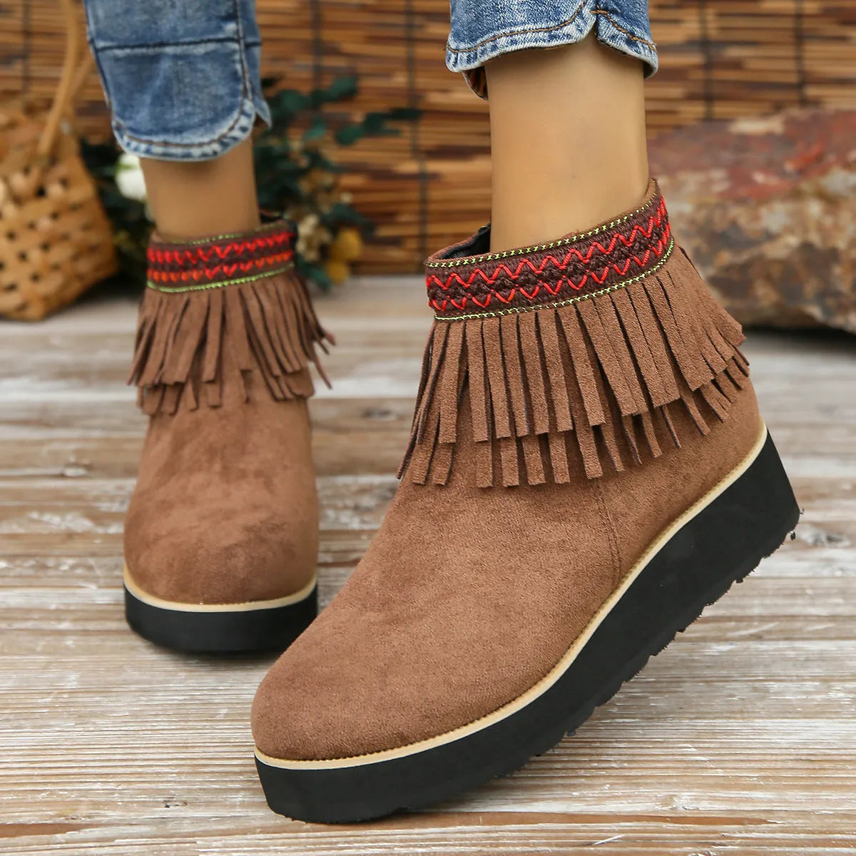 Women's dark brown suede ankle boots with a wedge heel, thick platform sole, tassel detail, and side zipper.