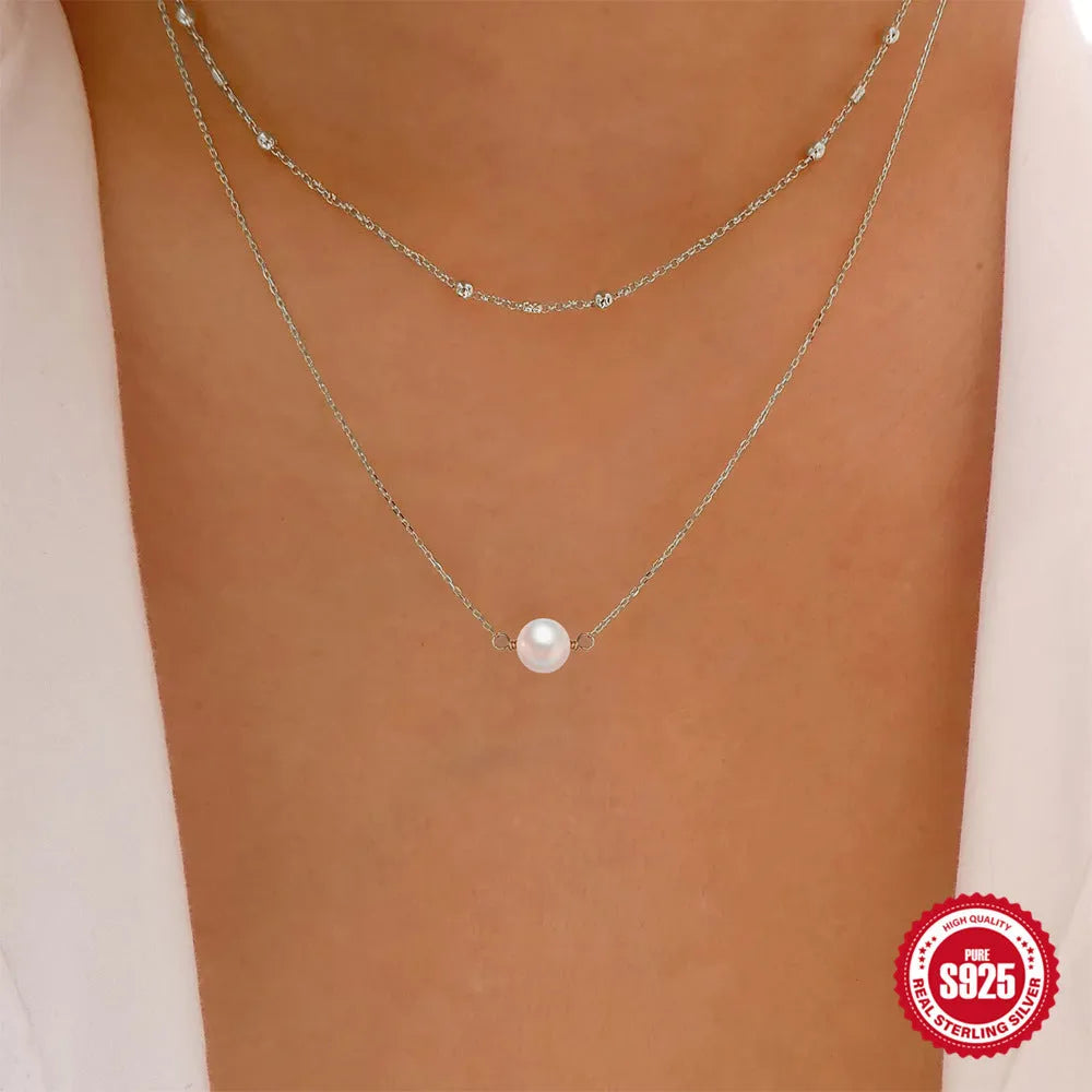Sterling silver geometric pendant necklace with two pearls, on a ball bead chain, shown in gold and white gold plating.