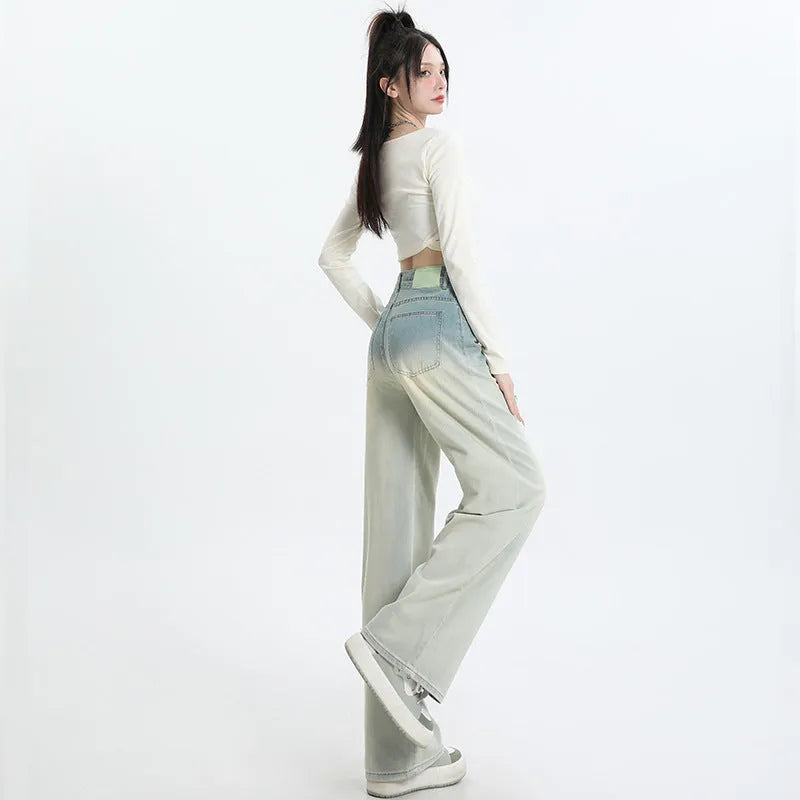 Women's gradient blue straight-leg denim trousers on a hanger, showing wide-leg silhouette.