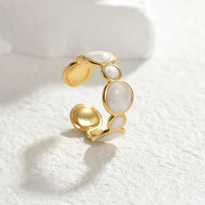 Silver geometric ring with adjustable opening on a plain background.
