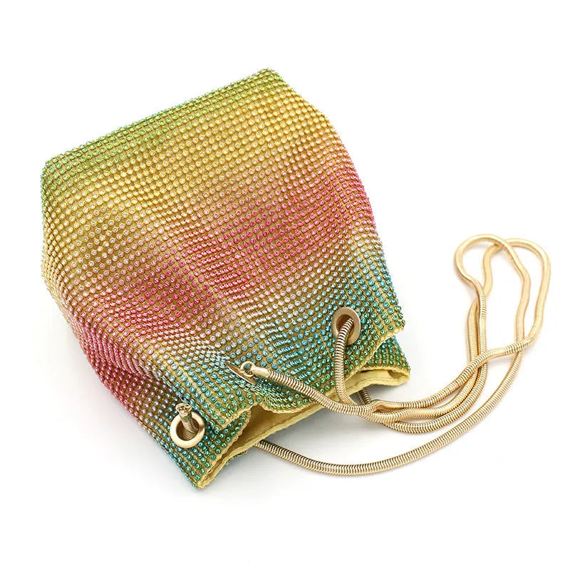 Rainbow coloured soft bucket handbag covered entirely in sparkling rhinestones with a top handle.