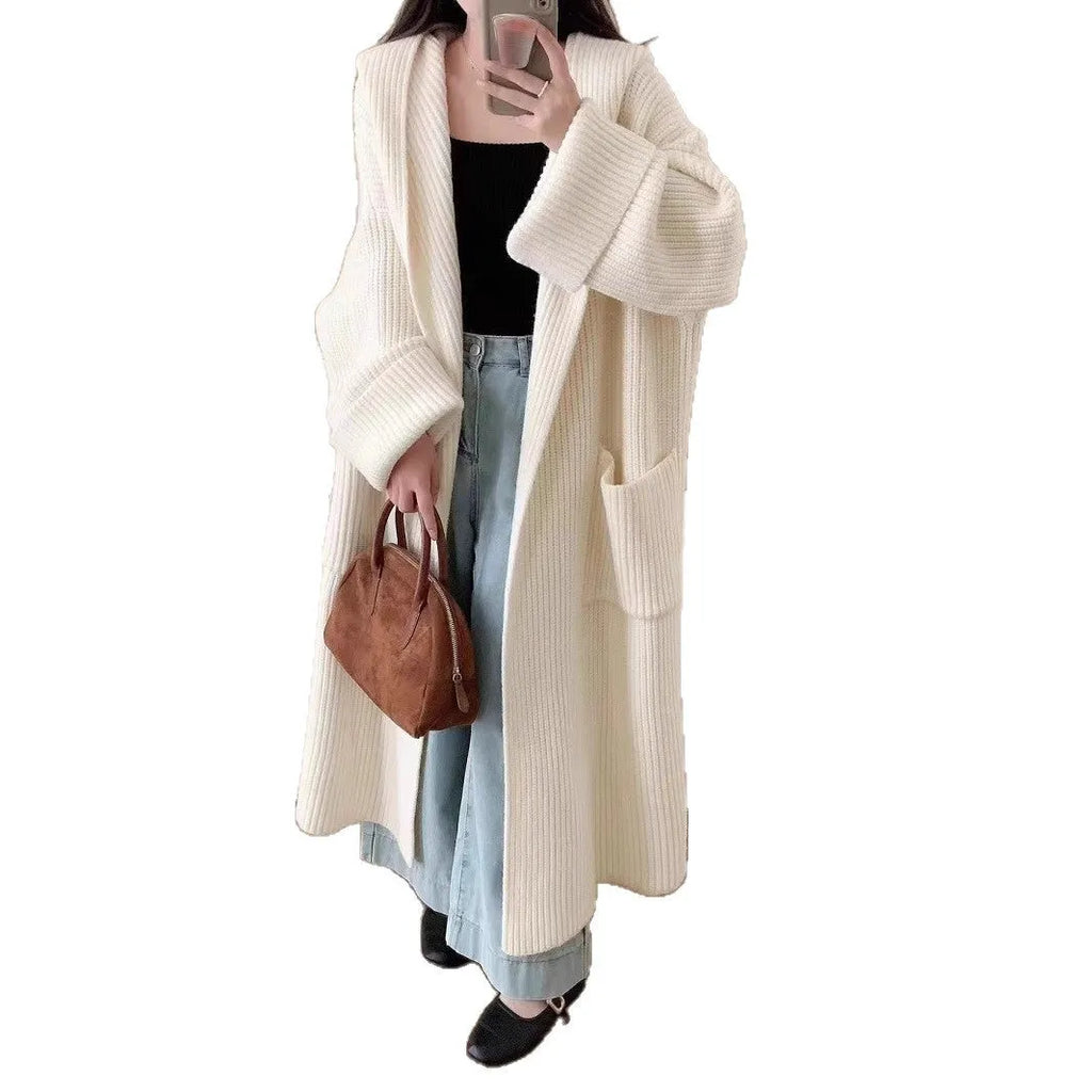 Loose-fitting beige hooded cardigan coat for women with raglan sleeves on a hanger.