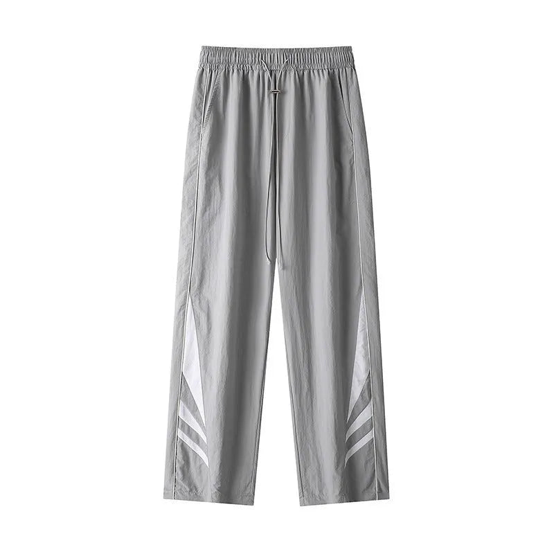 Men's straight leg trousers in black, showing button fly and elastic waistband on a hanger.