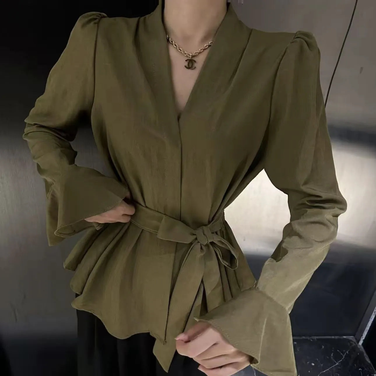 Women's black French-style shirt with an irregular collar and long bell sleeves, tied at the front.