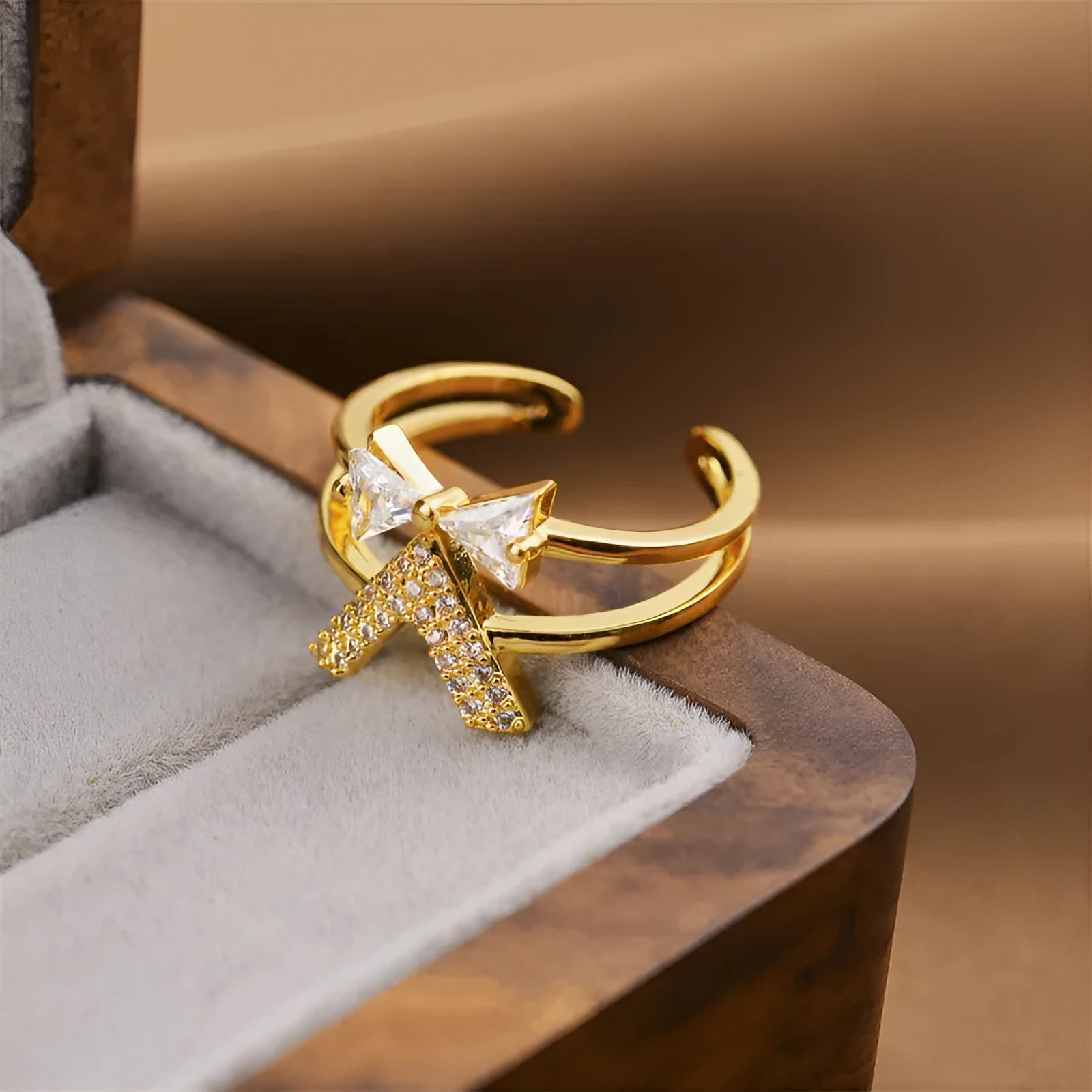 Gold geometric open fashion ring on a display stand, showing its adjustable shape.