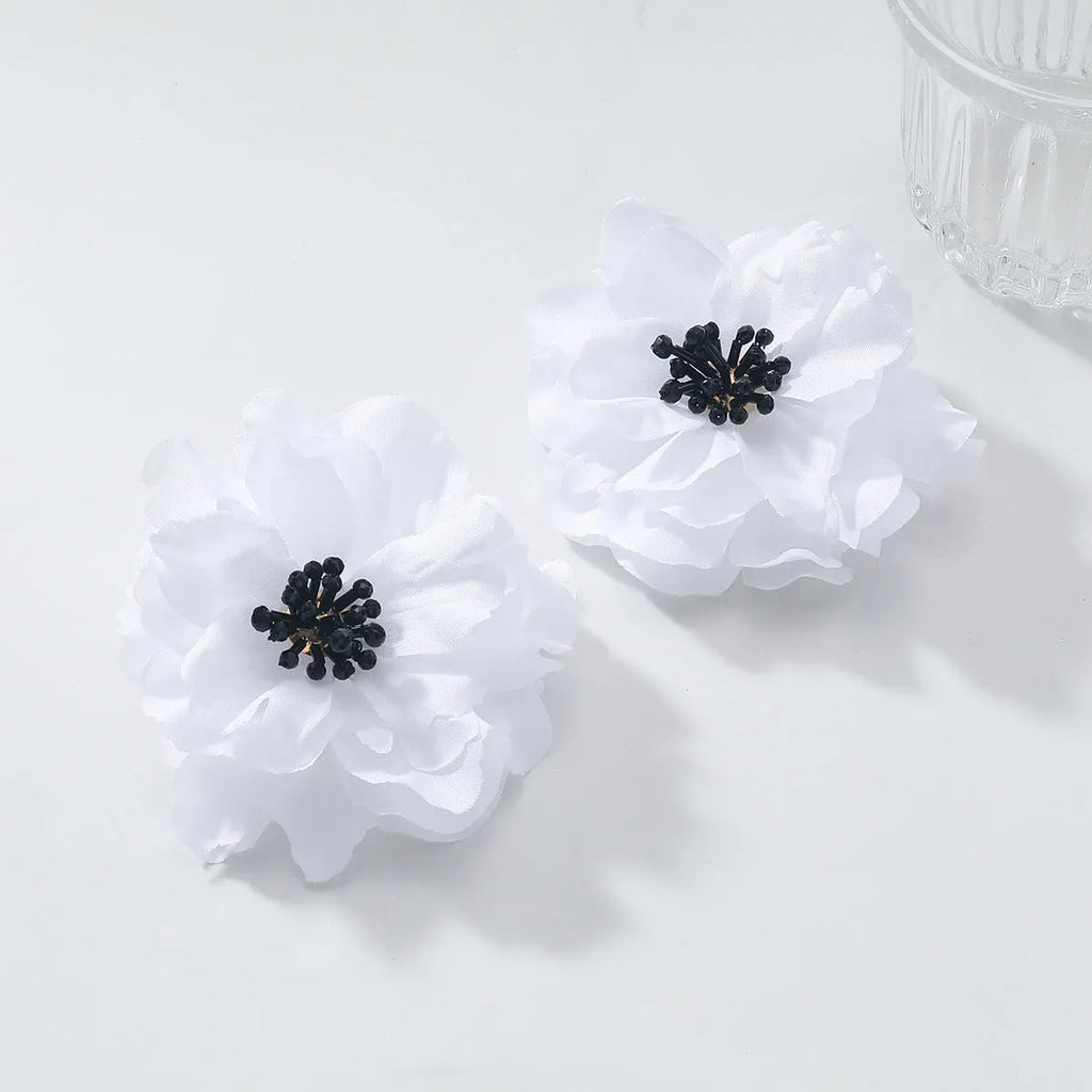 Hand-woven white plastic resin flower earrings for women fashion OL style on display