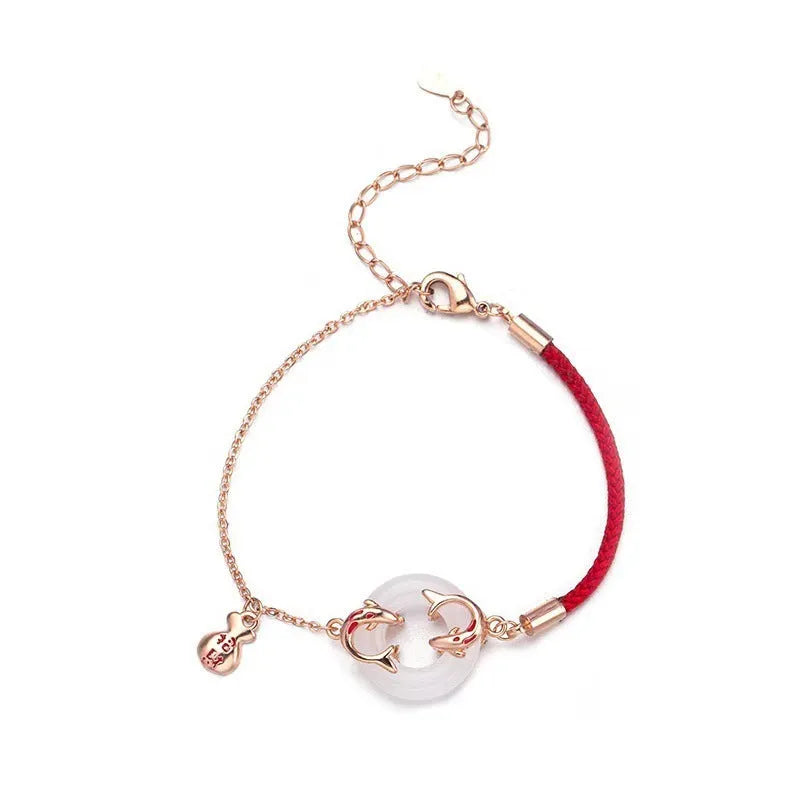 Festive Koi women's bracelet with red rope and peace buckle closure on a wrist.