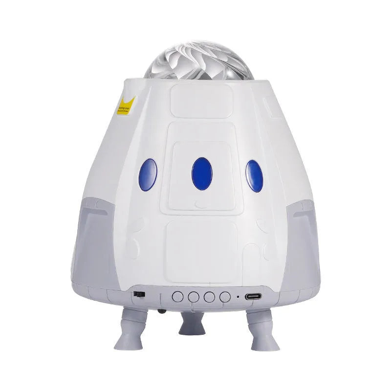 Space capsule shaped USB galaxy projection lamp with remote control on a desk.