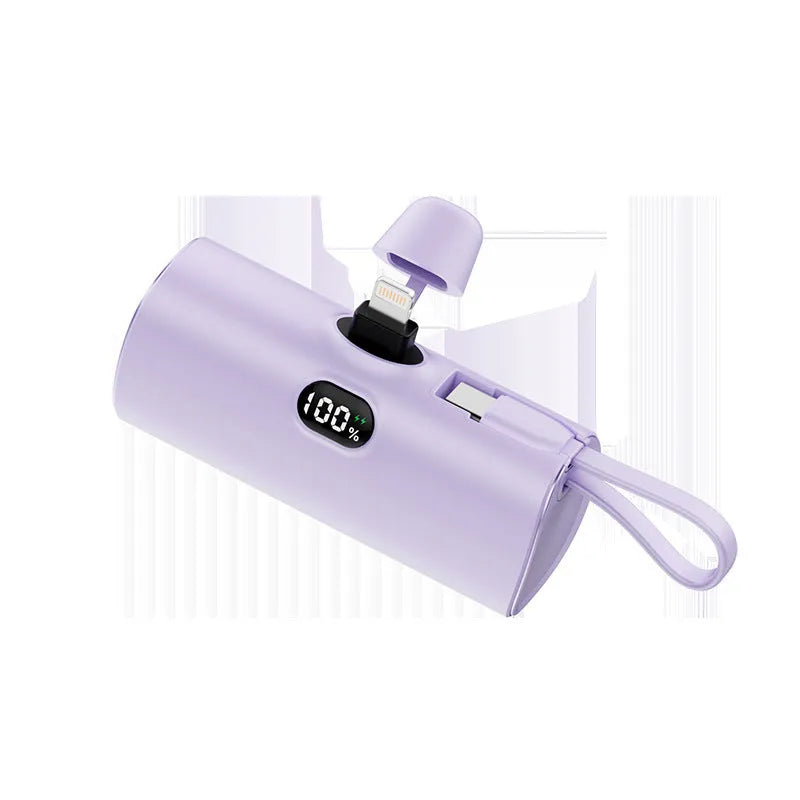 Compact capsule-shaped wireless power bank with digital display and integrated plug, shown in multiple colours.