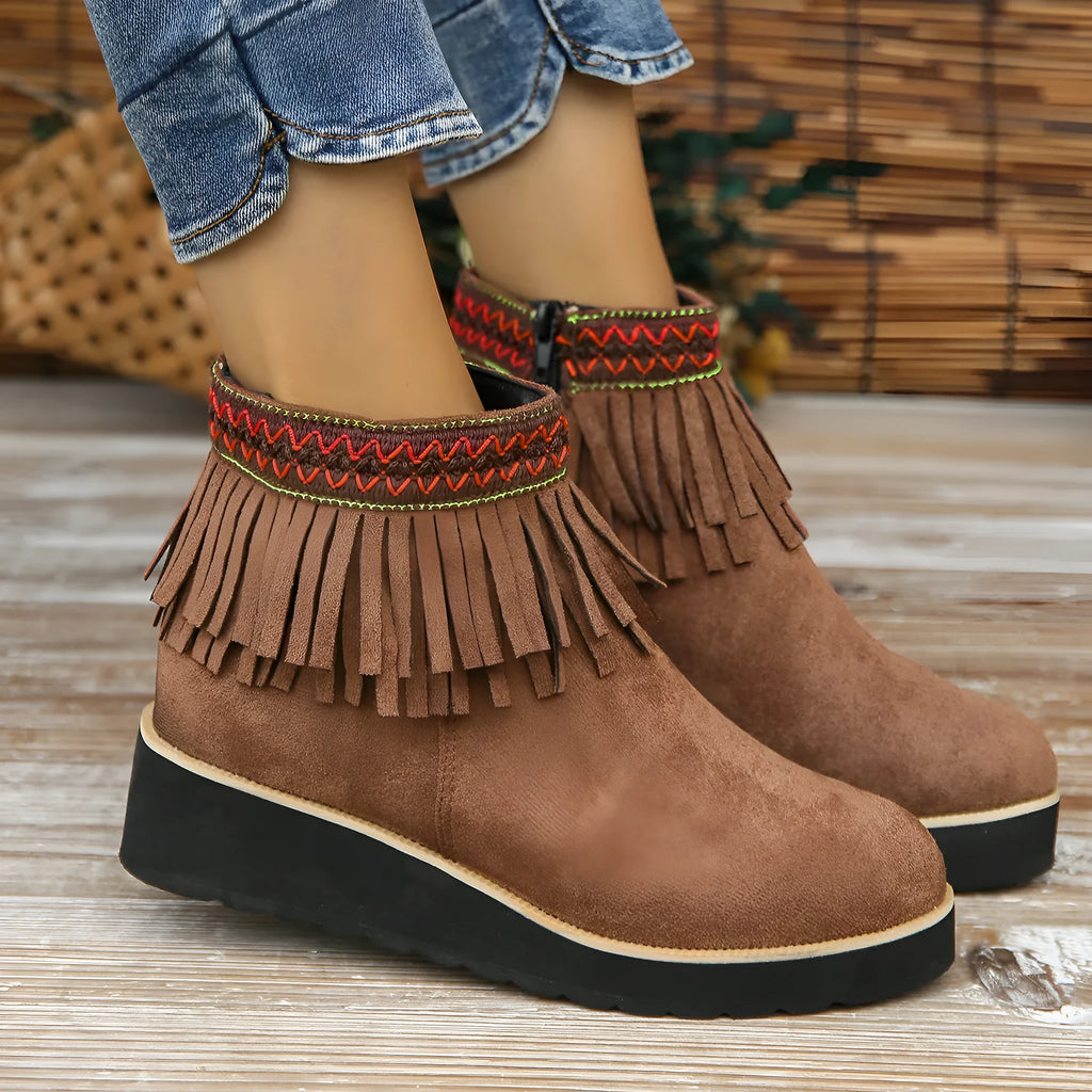 Women's dark brown suede ankle boots with a wedge heel, thick platform sole, tassel detail, and side zipper.