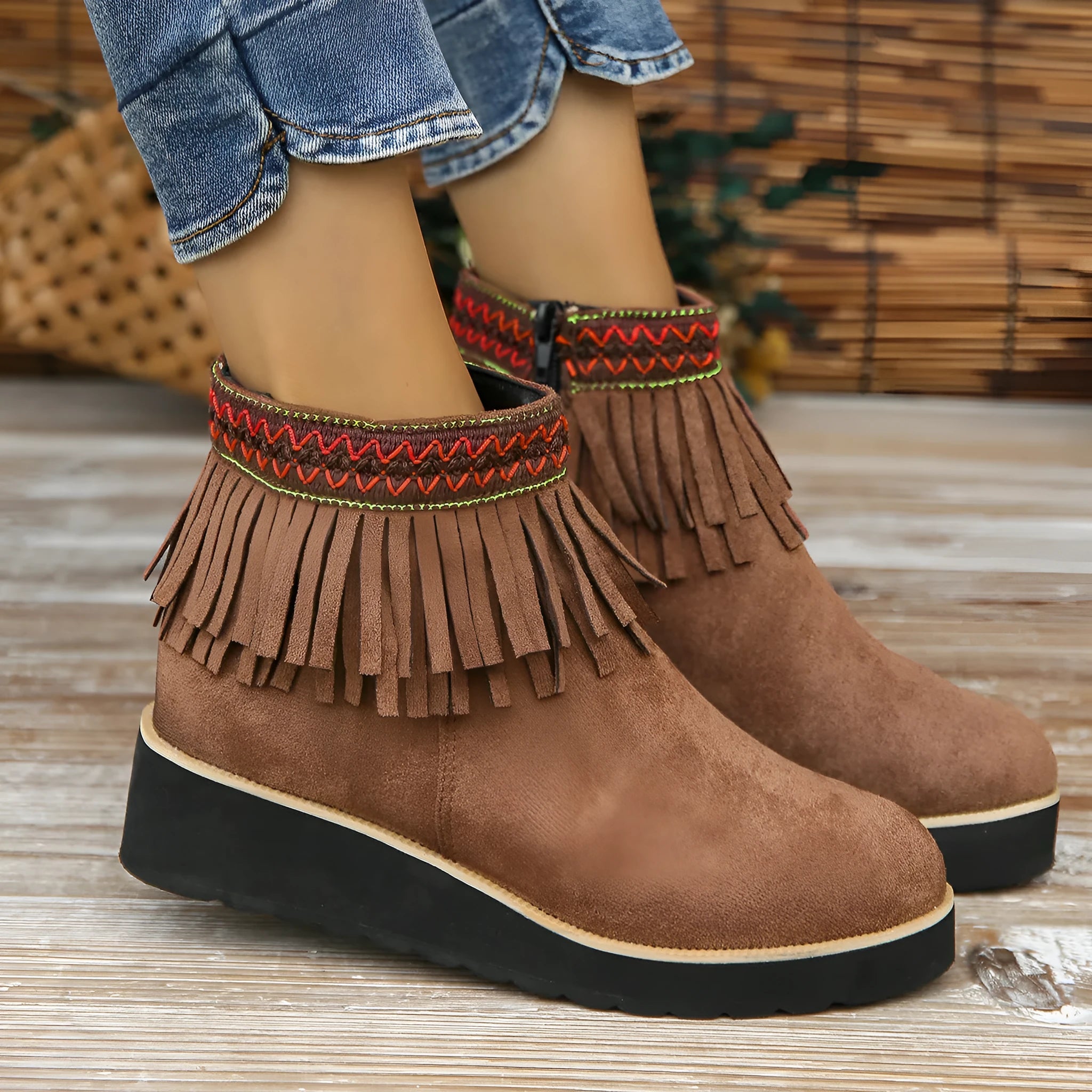 Women's dark brown suede ankle boots with a wedge heel, thick platform sole, tassel detail, and side zipper.