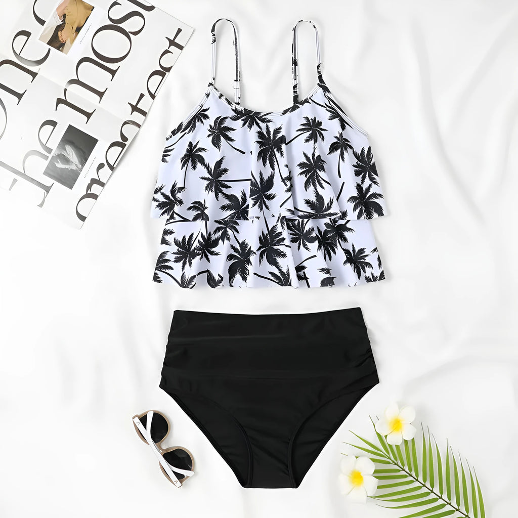 Black high-waisted two-piece swimsuit with a coconut tree print on a model, showing the brief style and double-layer construction.