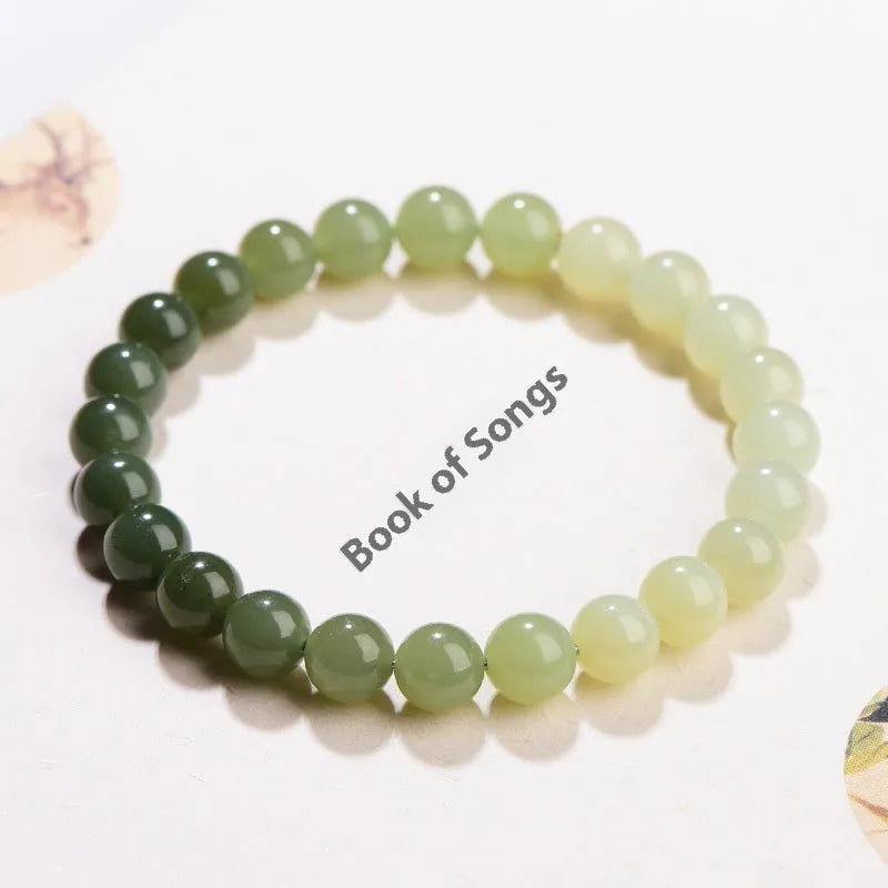 Natural clear water Hetian jade bracelet with gradient round beads on a wrist.