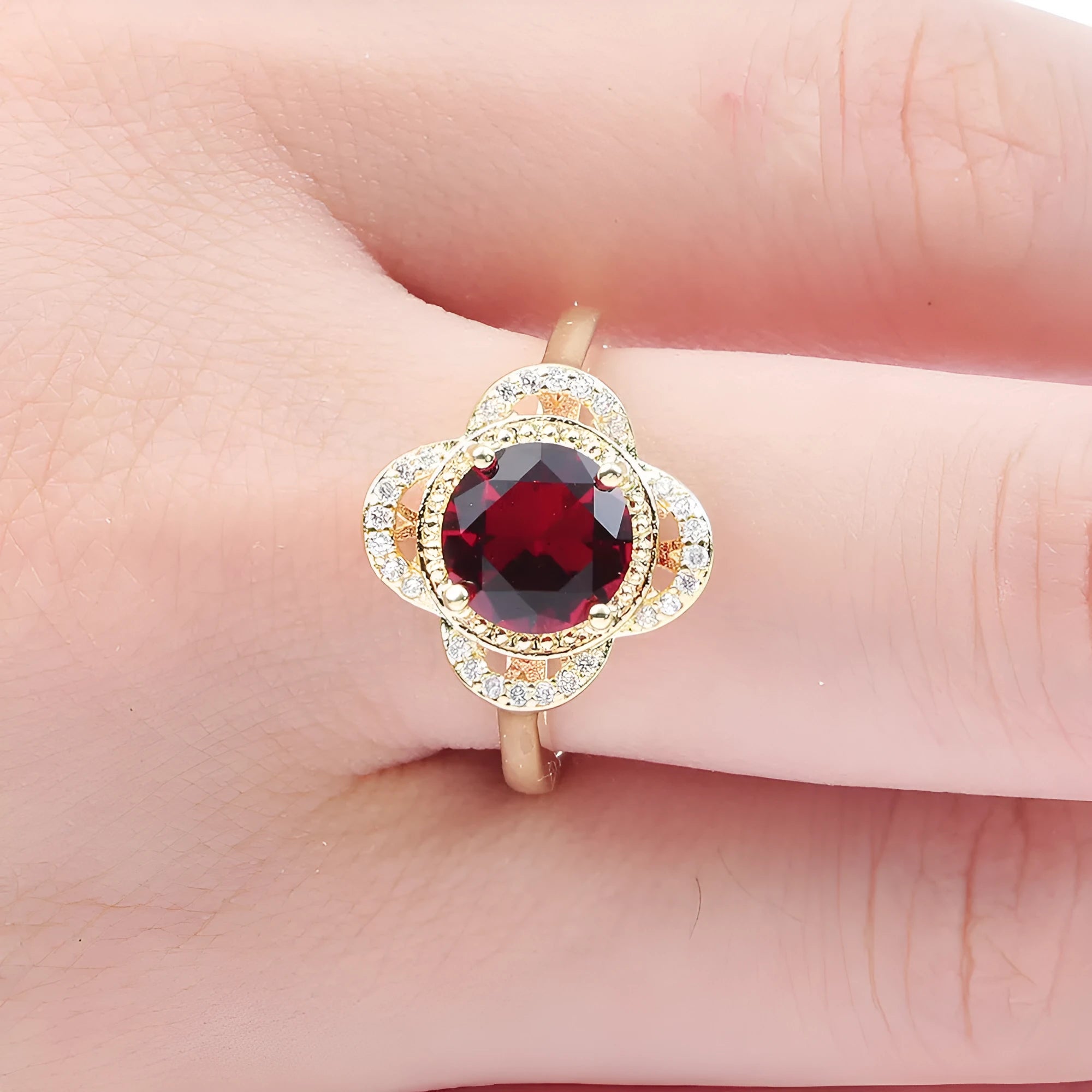 Copper fruit-shaped ring with a zircon stone, shown on a finger.