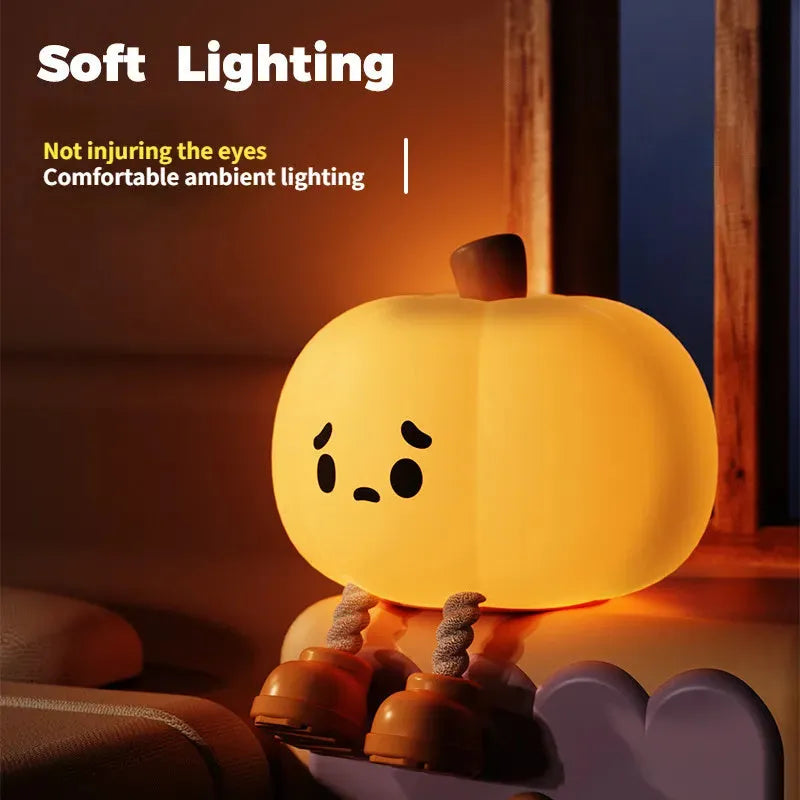 Soft orange silicone pumpkin-shaped night light with a gentle glow, sitting on a surface.