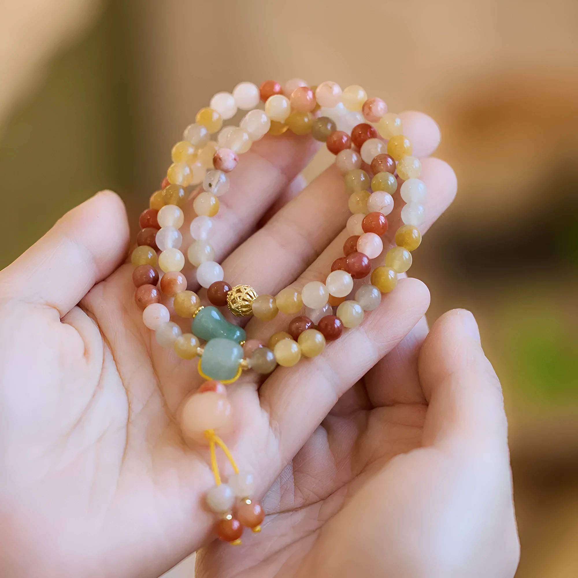 Women's Jinsi Jade bracelet with pumpkin tassel on a 14-16cm wrist.