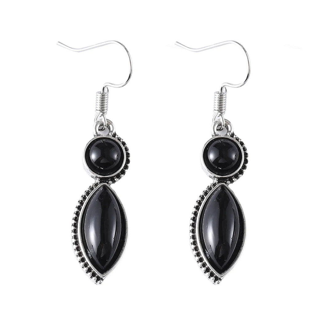Vintage silver-tone geometric drop earrings with round purple and black stones on a grey background.