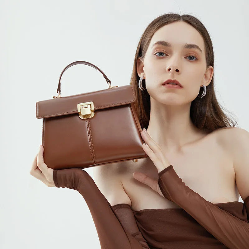 Women's black genuine vachette leather shoulder bag with clasp closure and 120cm strap.