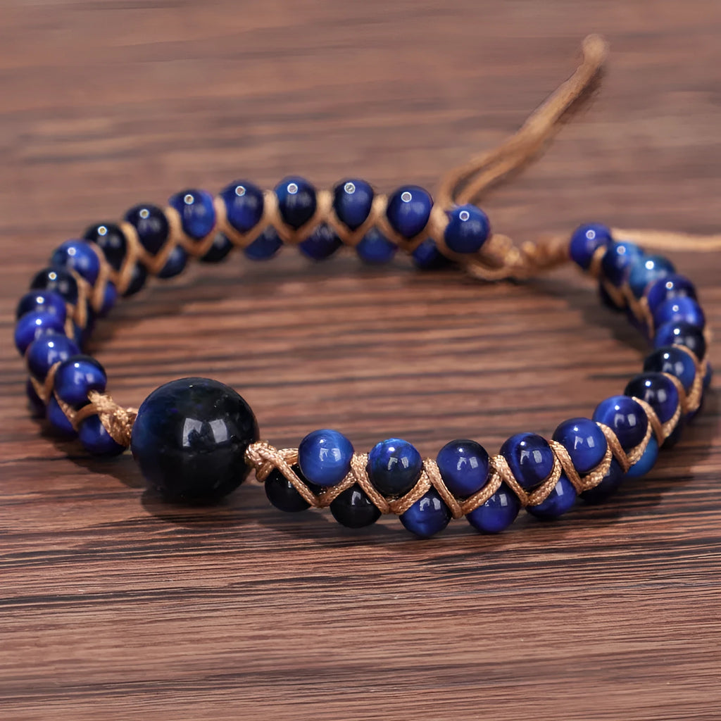 Close-up of a handmade geometric bracelet woven with blue Tigereye stone beads, showing its textured pull-on design.