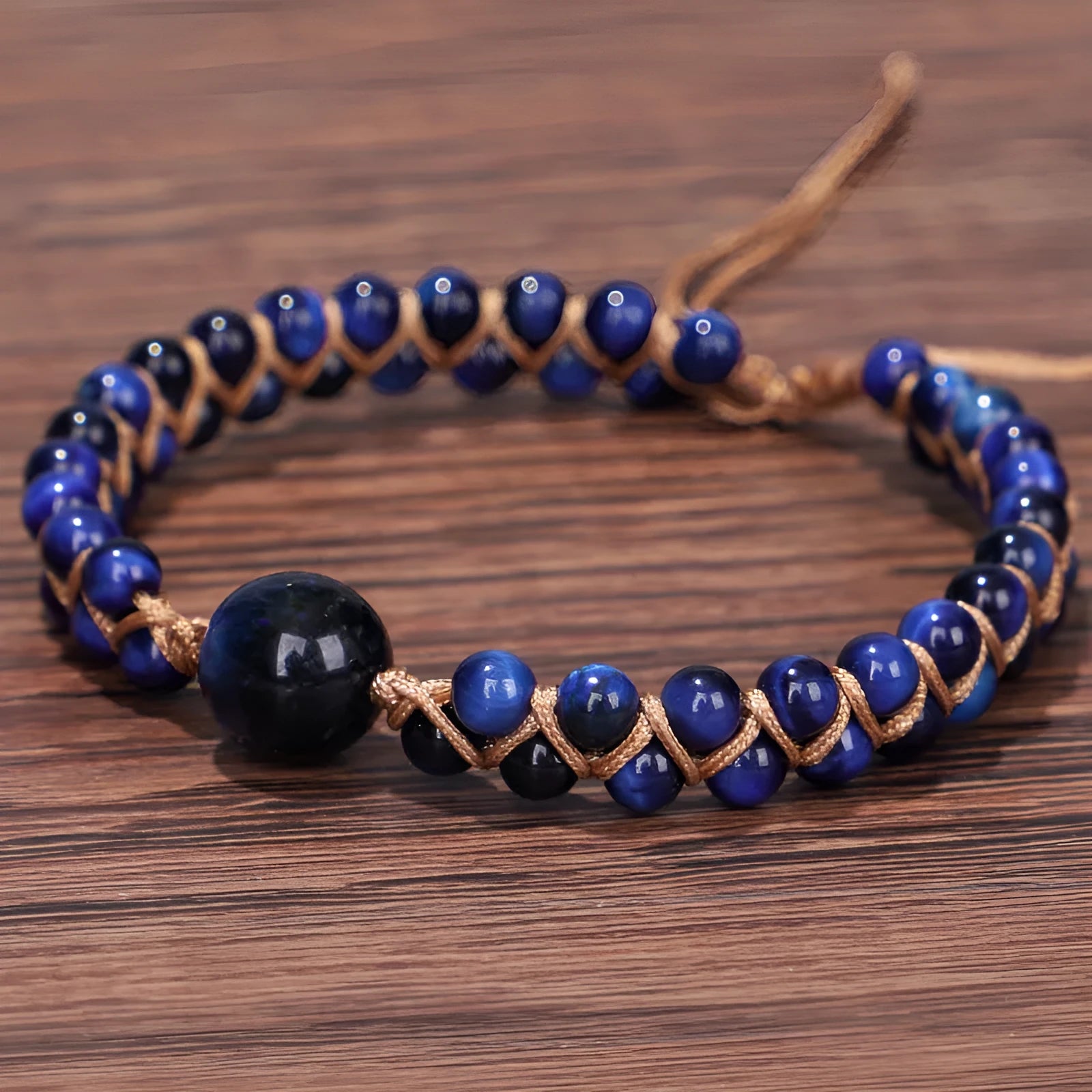 Close-up of a handmade geometric bracelet woven with blue Tigereye stone beads, showing its textured pull-on design.