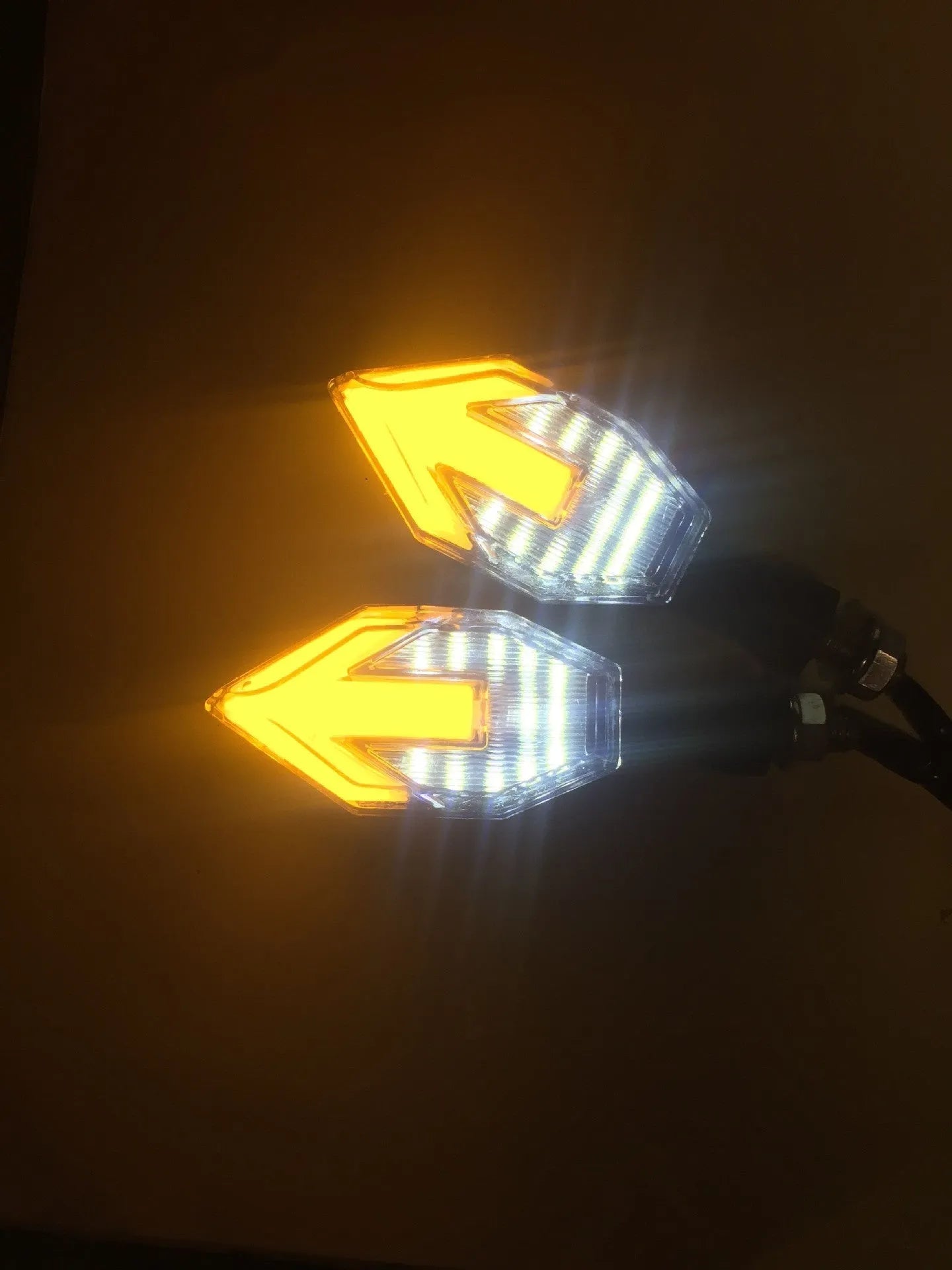 Arrow-shaped LED motorcycle turn signal light with 12V label and ABS plastic housing.